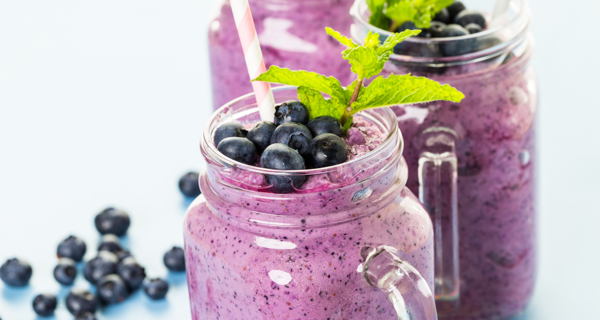 A delicious looking blueberry collagen smoothie in a tall glass.